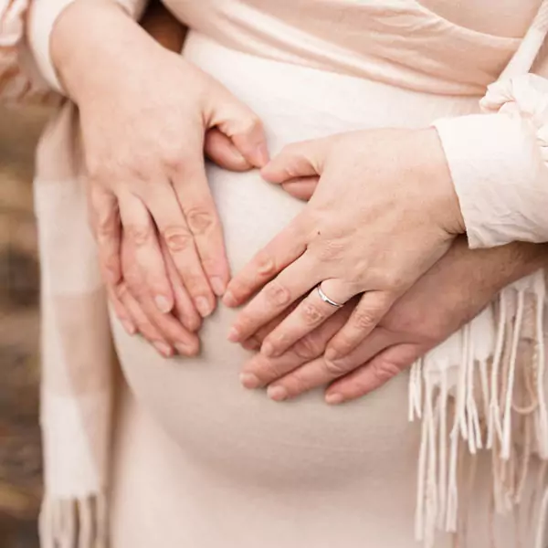 Babybauch Hände liegen auf dem Babybauch der werdenden Mama.