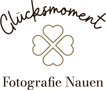 Logo Glücksmoment Fotografie Nauen. Der Schriftzug ist in zwei Zeilen aufgeteilt, getrennt durch ein stilisiertes Kleeblatt.