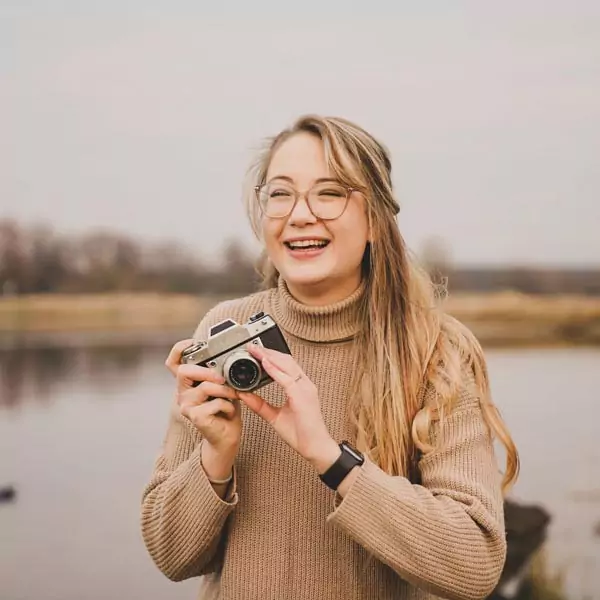 AlicaSiemens_2_quardat Alica lacht fröhlich und hält eine Kamera in der Hand.