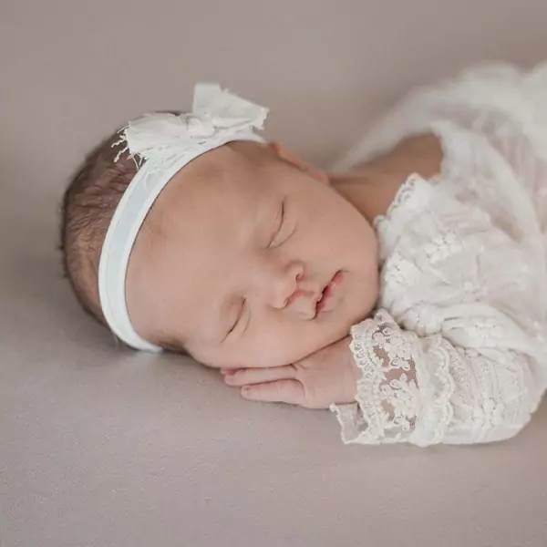 Newborn_neu Mutter und Baby liegen auf weichem Untergrund.